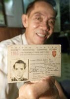 Pham Xuan An raises his press card in 1965 during an interview with AP reporters in 2000 (Photo: AP)